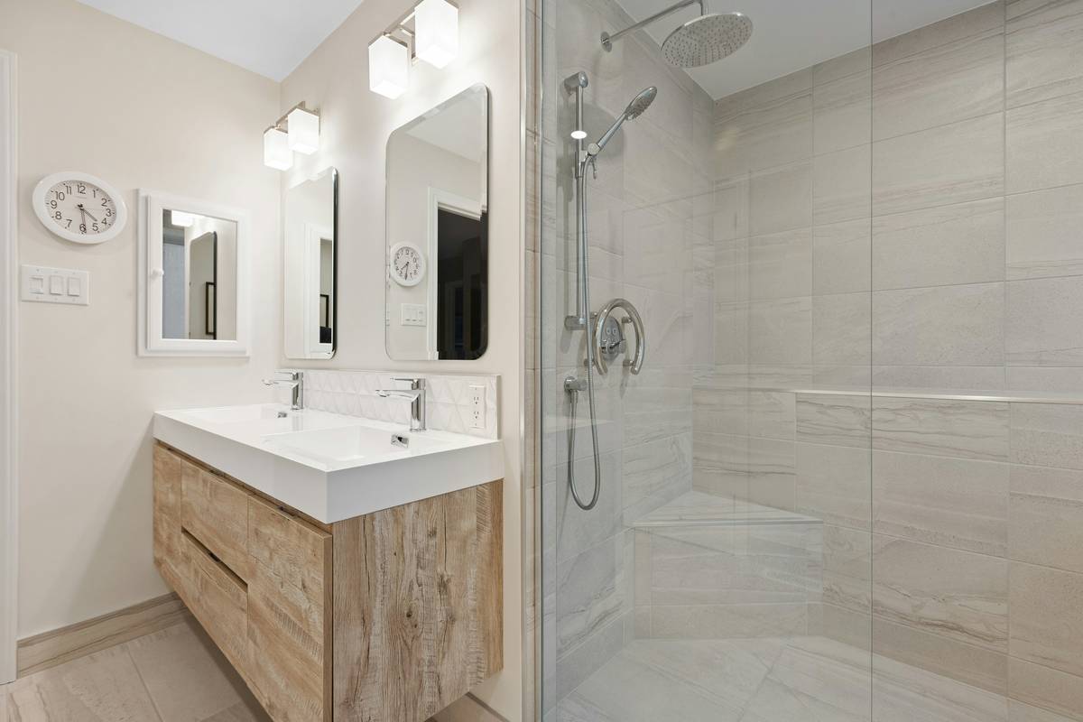 diy shower enclosure ideas: overhead view of a completed walk-in shower with frameless glass panel, tiled floor, and recessed niche